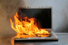 笔记本电脑损坏。笔记本电脑着火着火了。电脑维修。火光手提电脑.