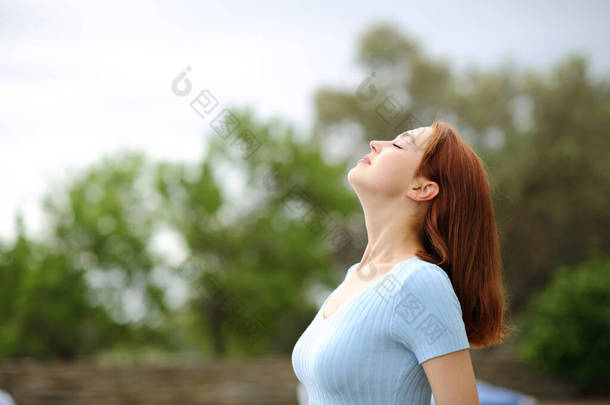 Profile of a happy woman breathing fresh air in a garden