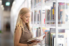 站在书店或图书馆里看书的年轻妇女或女孩.