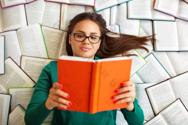 女生在考试准备过程中躺在书本上看书的头像