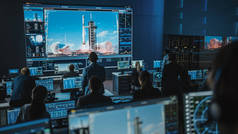 任务控制中心人员小组见证了成功的空间火箭发射。飞行管制员坐在电脑前展示及监察飞行任务。团队精神站起来观看.