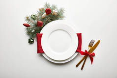 装饰松枝的白色背景圣诞餐桌的顶视图