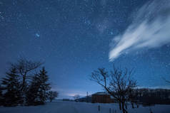 星光灿烂的天空和房子在喀尔巴泰山脉的夜晚在冬天