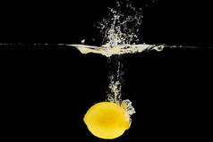 黄色成熟的柠檬落水深，溅到黑色
