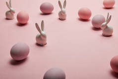 玩具兔子和彩绘复活节彩蛋在粉红色的背景