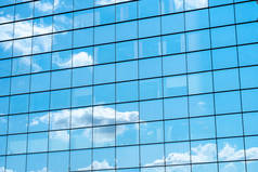 城市建筑镜面墙上蓝天白云的倒影.