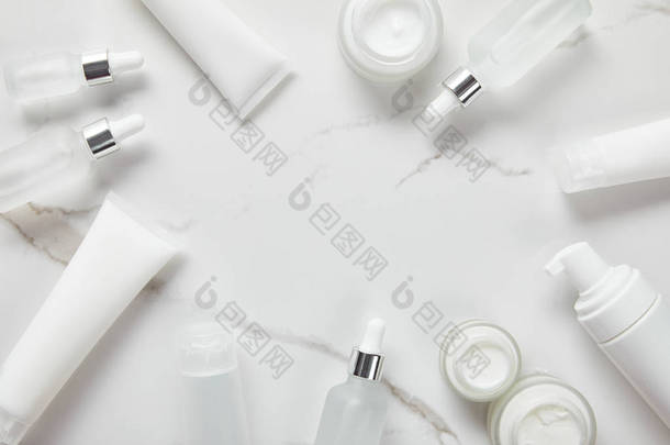 化妆品玻璃瓶的顶视图，带奶油的罐子，保湿剂管，分配器和茉莉花在白色表面