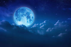 美丽的蓝色月亮在天空和星星在夜间多云的后面。Outd