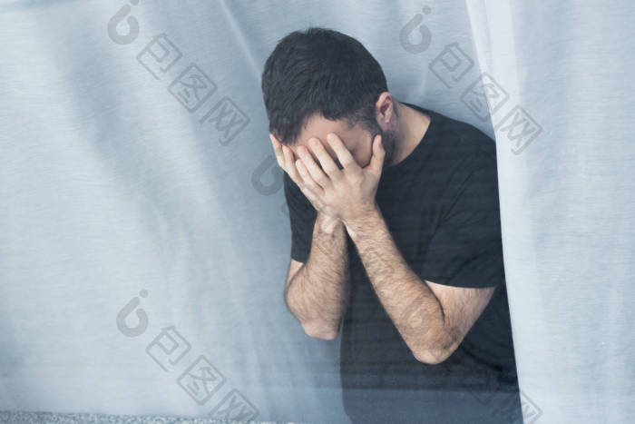 孤独的人站在窗口手牵着脸的高角度视图图片-包图网企业站