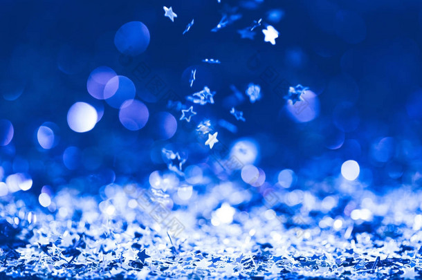 圣诞背景与下落的蓝色闪亮的五彩纸屑星