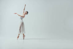 迷人的芭蕾舞演员在白色的礼服舞蹈工作室, 孤立的白色