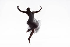 美丽的年轻芭蕾舞女郎跳舞在白色礼服孤立在白色