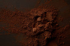 在黑暗背景下的美味巧克力片和美味可可粉的顶级视图