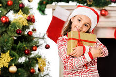 美丽的小孩子拿着圣诞礼物, 看着相机