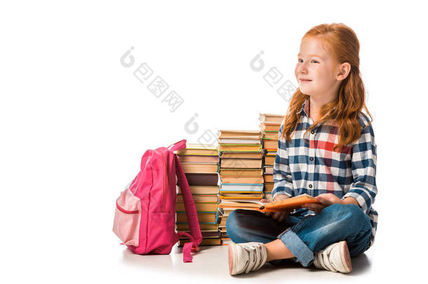 积极的红头发学童坐在<strong>书本</strong>旁边，<strong>白色</strong>的粉色背包上