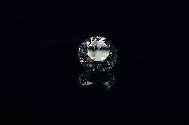 透明纯净的闪闪发光的钻石隔离在黑色与反射