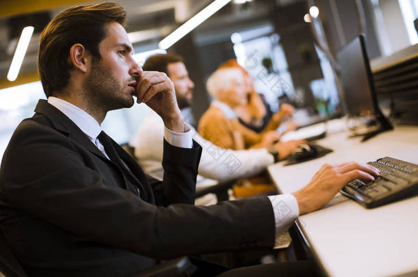在现代办公室用计算机与其他商人和女商人举行的集体会议中对商人高管的看法