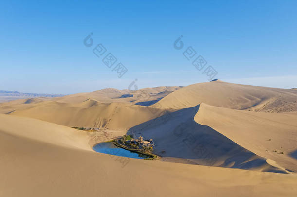 美丽的月牙湖在歌唱的沙山中，甘肃敦煌沙漠奇观.