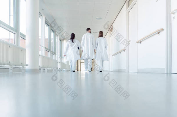 三个医生走在医院的走廊上