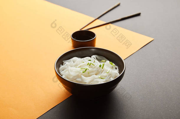 米粉在靠近筷子的碗中的选择性聚焦及黄黑相间酱油