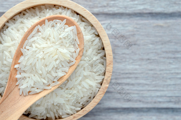 生的米在碗上白色木背景