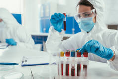 生物化学家在实验室的同事附近拿着血样试管