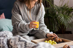 早餐的女孩藏品玻璃橙汁的裁剪图像