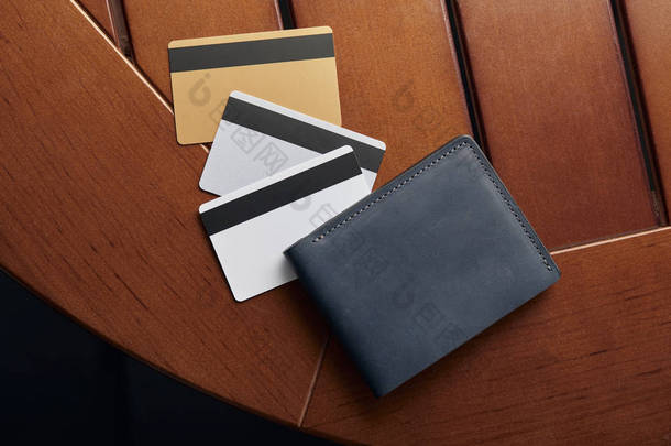 木桌上信用卡和皮夹的顶视图