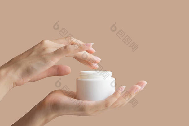 女人的手把手指伸进装有奶油的白色<strong>包装</strong>模型里。身体护理的概念，<strong>美容</strong>业