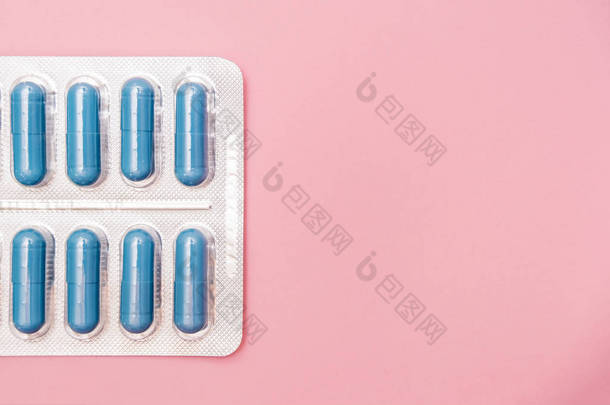 治疗性传播疾病的抗生素和抗菌药丸Std，粉红色背景的蓝色水泡胶囊，复制空间