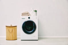洗澡间洗衣篮附近洗衣机上的洗涤剂瓶、毛巾和设备