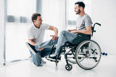 微笑物理治疗师按摩腿的残疾人在轮椅上