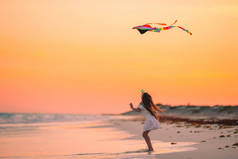 小女孩在沙滩上放风筝，用浑浊的水