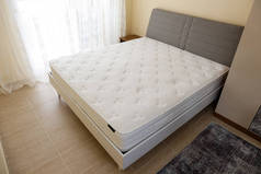 卧房未制床上的白色骨科床垫顶部侧面图案。低过敏性泡沫床垫，用于适当的脊柱韧带和减压点。背景，复制空间，关闭.