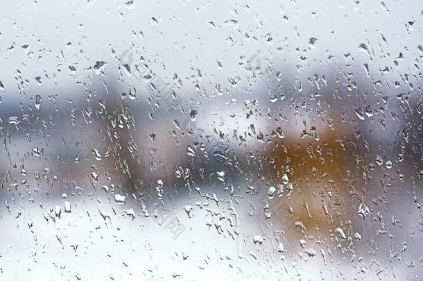 雨天的城市背景。窗玻璃上的雨滴。用雨滴把家里的窗户弄湿.