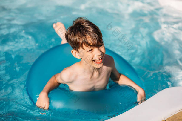 夏日游泳池中的充气环的快乐男孩肖像