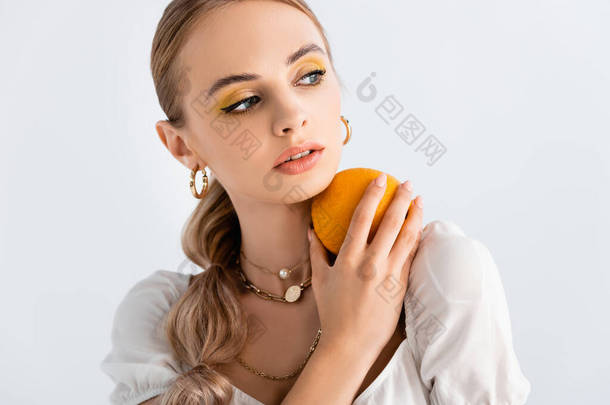 <strong>优雅</strong>的金发女人摆出<strong>橙色</strong>的姿势，孤零零地看着白色的脸庞