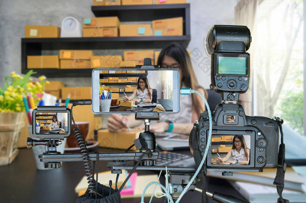 专业的相机与智能手机和动作摄像头在三脚架上的年轻企业妇女在家<strong>中</strong>进行网上购物, 为企业家概念<strong>直播</strong>流