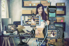 专业的相机与智能手机和动作摄像头在三脚架上的年轻亚洲青少年业主商业妇女在家中为网上购物, 生活流的企业家概念