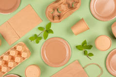 平面布局组成与环保餐具和绿色背景的牛皮纸食品包装。可持续包装,可循环利用的纸制品,零废物包装概念.Mockup, selective focus