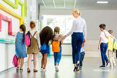 小学生的后观与学校走廊的教师步行