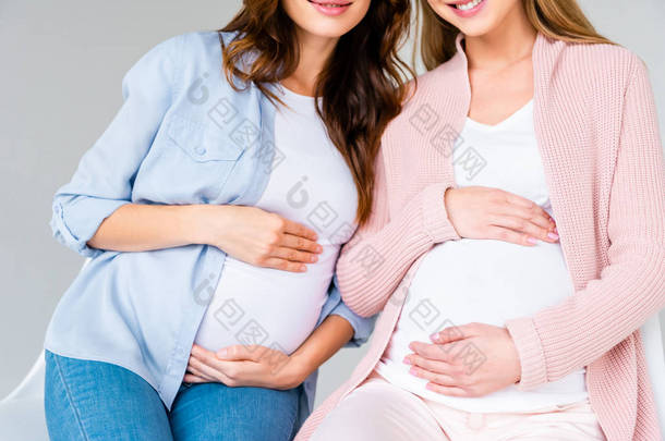 裁剪视图怀孕的微笑的妇女坐在产前类隔离在灰色