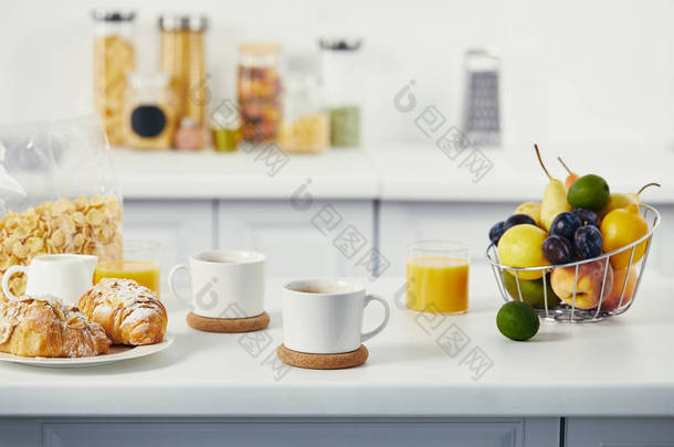 厨房<strong>白色桌面上</strong>的早餐杯咖啡和牛角面包的特写视图