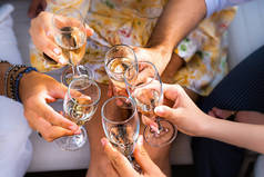 大家一起来敬酒的朋友- -手握香槟酒长笛的细节- -活动、生日、周年纪念日或庆祝生活方式的概念- -关注左手