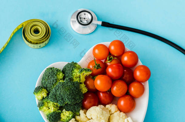 美味的有机蔬菜在心形板附近测量<strong>胶带</strong>和听诊器在<strong>蓝色</strong>