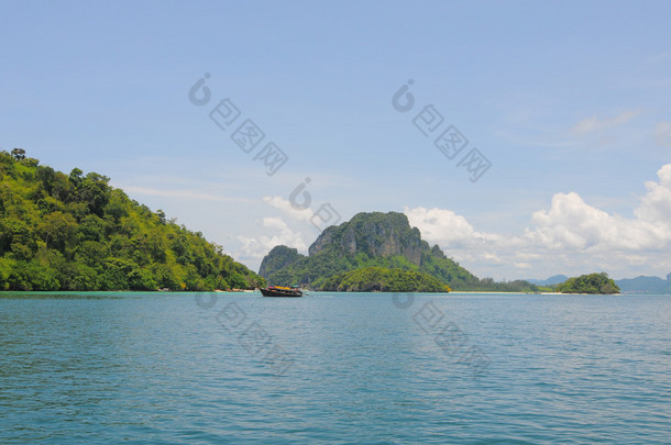 甲米，泰国的-Sep 12，2015年。在阳光明媚的日子，在甲米的美丽海滩上的旅游船。旅游业是泰国南部的重要产业.