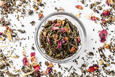 绿茶, 在一个玻璃碗里, 用干花花瓣和柑橘片。用于焊接的干茶。饮食和健康饮料。弗拉特利顶视图