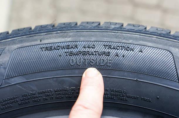 轮胎牵引等级、胎面磨损指数和轮胎外部指定的新轮胎侧视图