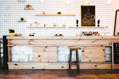 木棕色酒吧柜台与植物和纸杯蛋糕, 画在架子上的咖啡屋