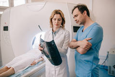 周到的医生在Ct扫描仪上观察病人诊断期间的X射线诊断